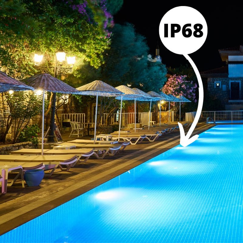 Piscine extérieure la nuit avec un luminaire indice de protection IP68 à l'intérieur