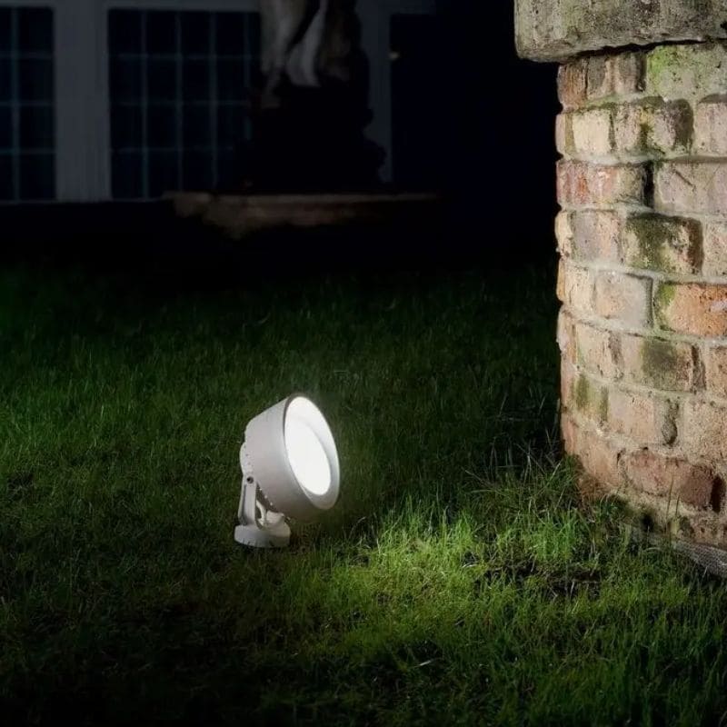 Projecteur blanc Tommy de la marque Ideal Lux, Indice de protection IP66 dans un jardin sous la pluie