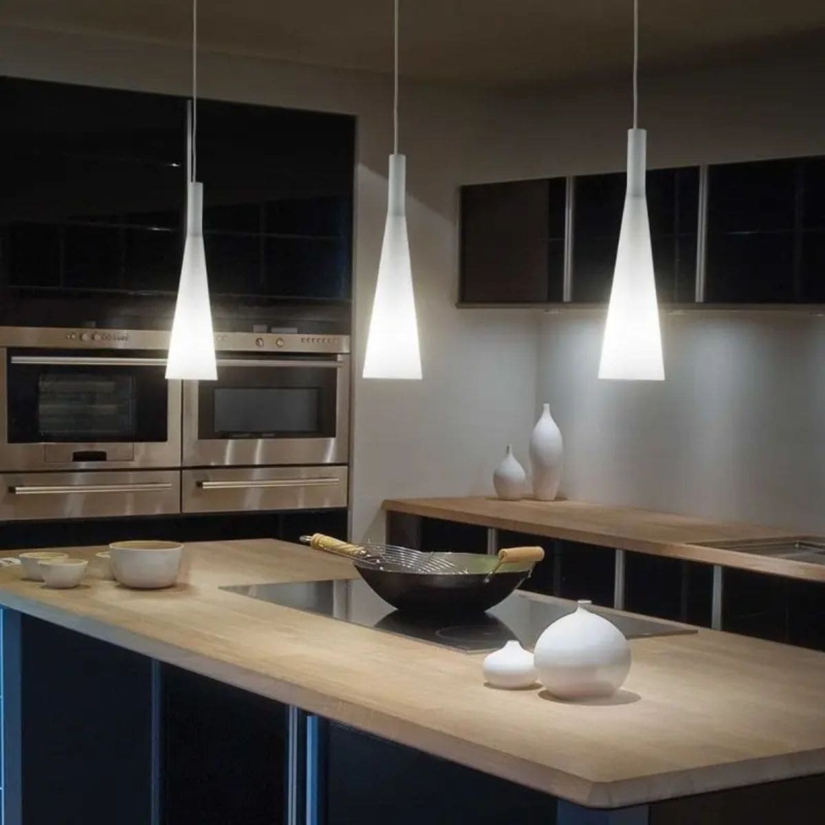 Suspension blanche dans une cuisine moderne en noir et bois, pour laisser de la lumière à son chat la nuit