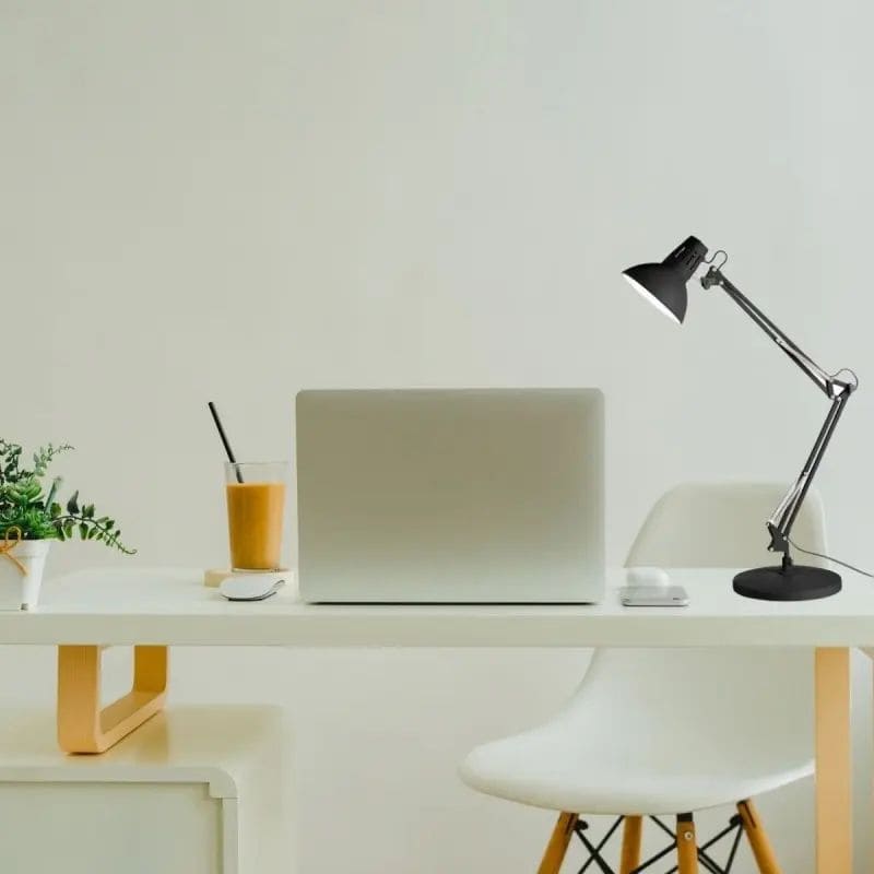 Lampe articulée noir sur bureau blanc avec ordinateur portable, pratique pour bien éclairer son bureau sur une zone ciblée