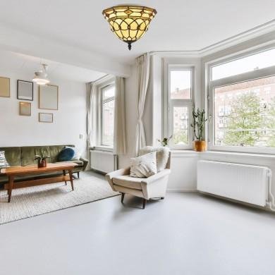 Différence suspension et plafonnier : salon lumineux avec lustre au plafond et plafonnier discret près des fenêtres.