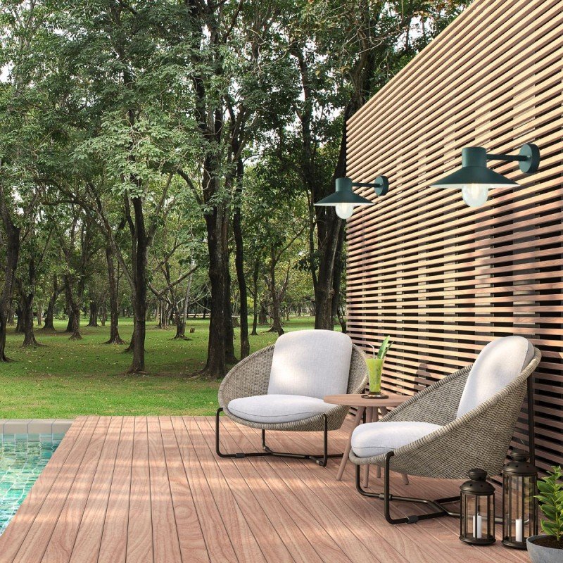 Installation éclairage extérieur jardin avec chaises sur terrasse en bois près d’un mur en lames et lampes murales autour de l’espace détente.