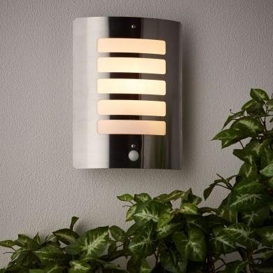 Luminaire exterieur sans électricité mural moderne éclairant une terrasse près de plantes vertes.