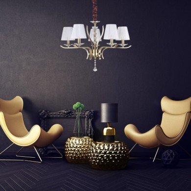 Lustre chic et moderne suspendu au-dessus d’un salon avec fauteuils orange et table lumineuse dorée, ambiance design élégante.