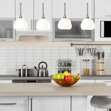 Suspensions lumineuses élégantes au-dessus d’une cuisine moderne, éclairage pendants pendant et fruits dans un bol sur le plan de travail. luminaires tendance pour le salon en 2026