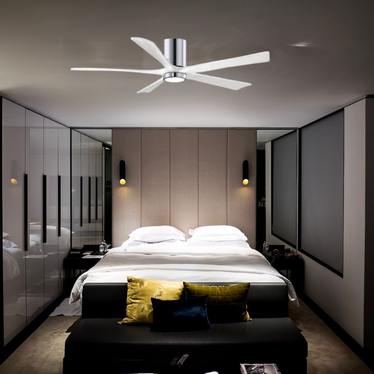 Ventilateur plafond avec lumière et télécommande silencieux installé au-dessus d’un lit queen-size dans une suite moderne, avec canapé et coussins colorés.