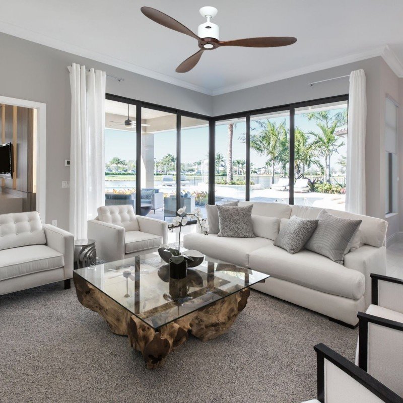 Ventilateur plafond ultra silencieux fonctionnement dans un salon lumineux, plafonnier blanc, canopée moderne et grande baie vitrée avec vue jardin extérieur.